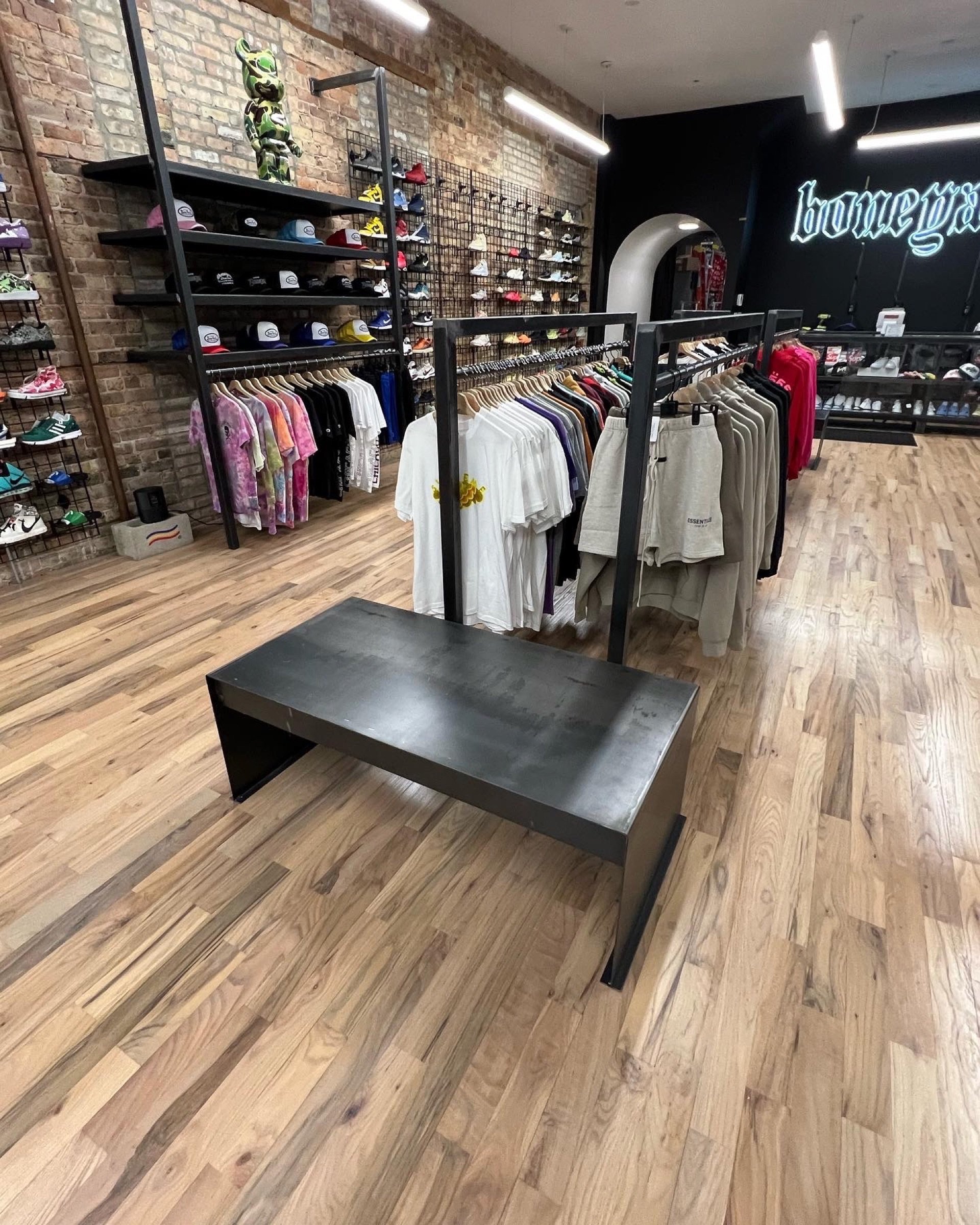 Angled view of the Boneyard retail interior with branded wall, display shelving, and apparel racks