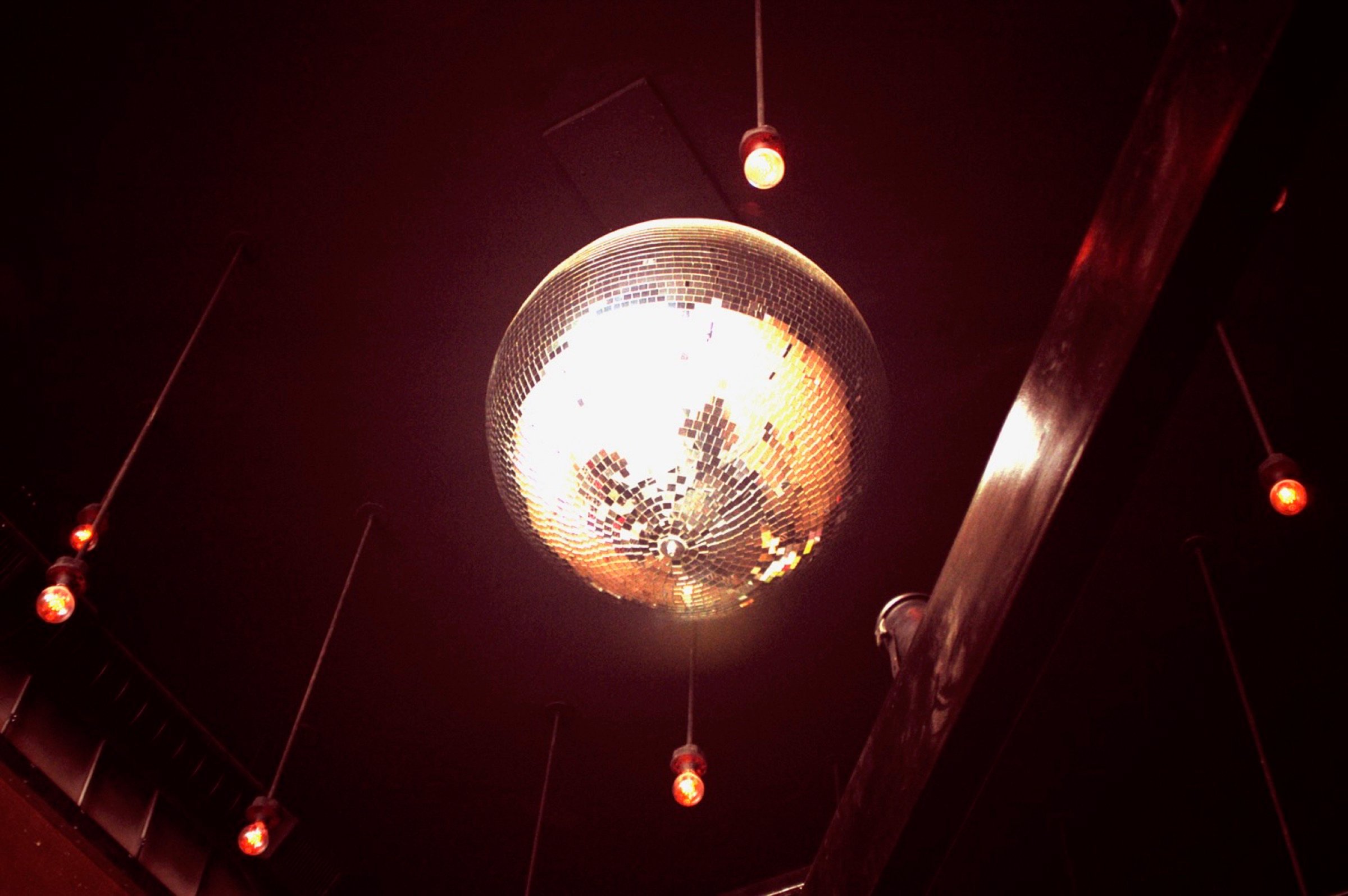 Disco ball and warm pendant lighting over the bar at Blue Bar