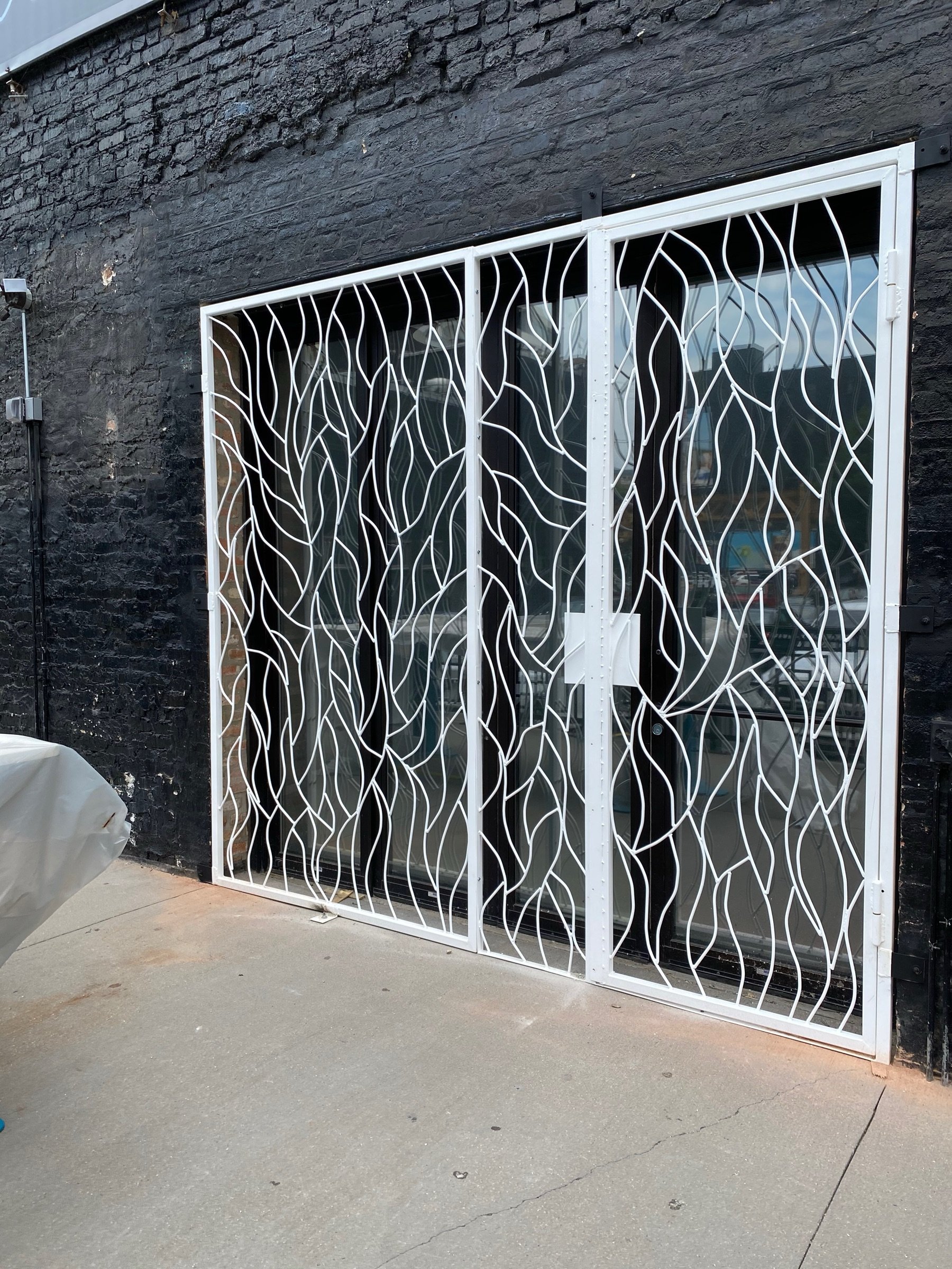 Stone-framed section of the Moca facade with vine-pattern metalwork