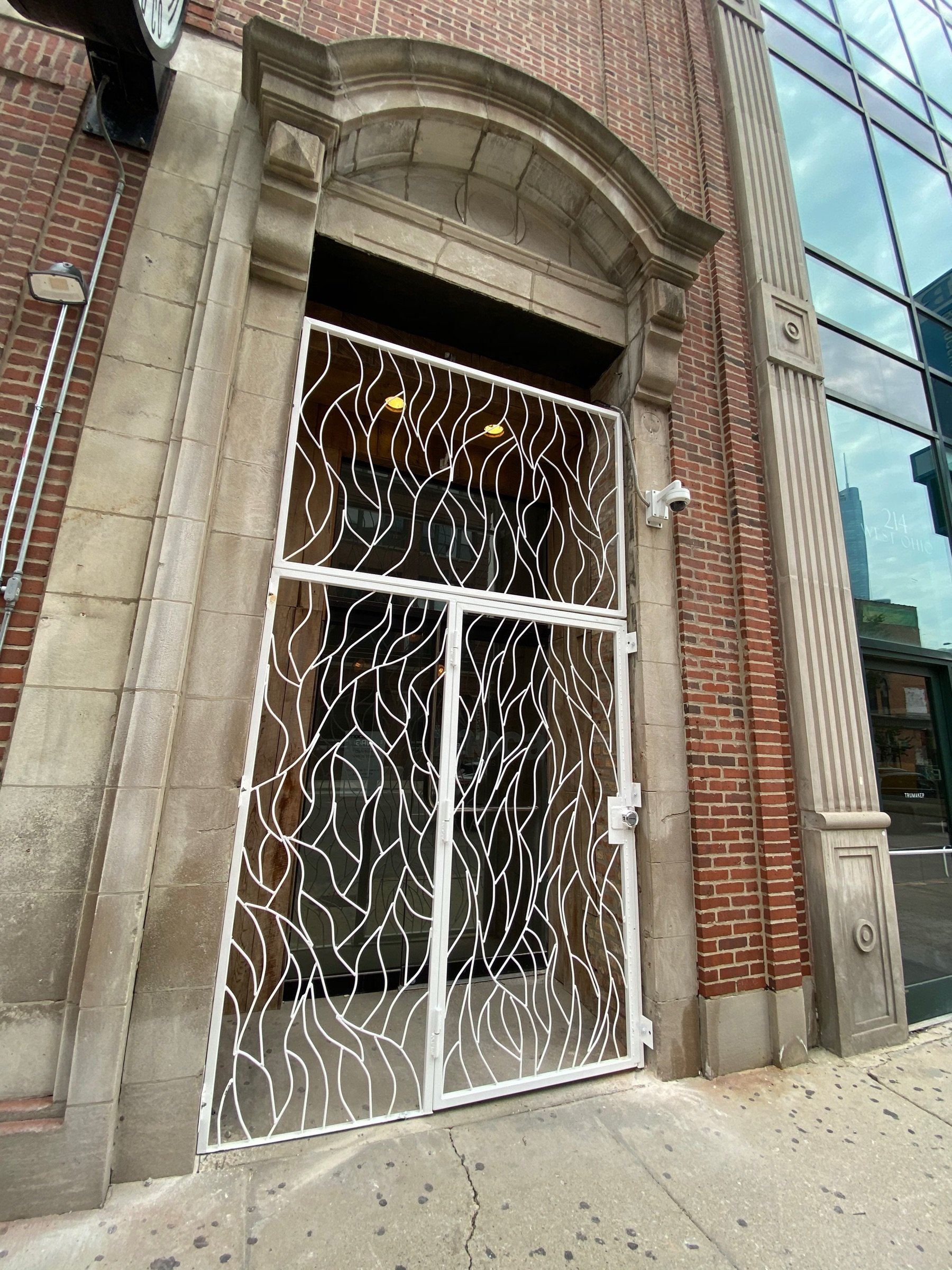 Arched entry panel with hand-forged vine-pattern metalwork at Moca