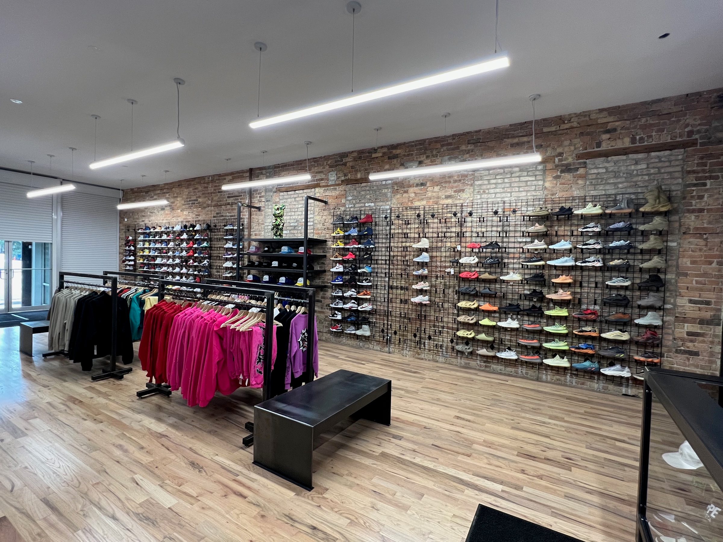 Wide view of the finished Boneyard retail interior with custom metal display fixtures and exposed brick