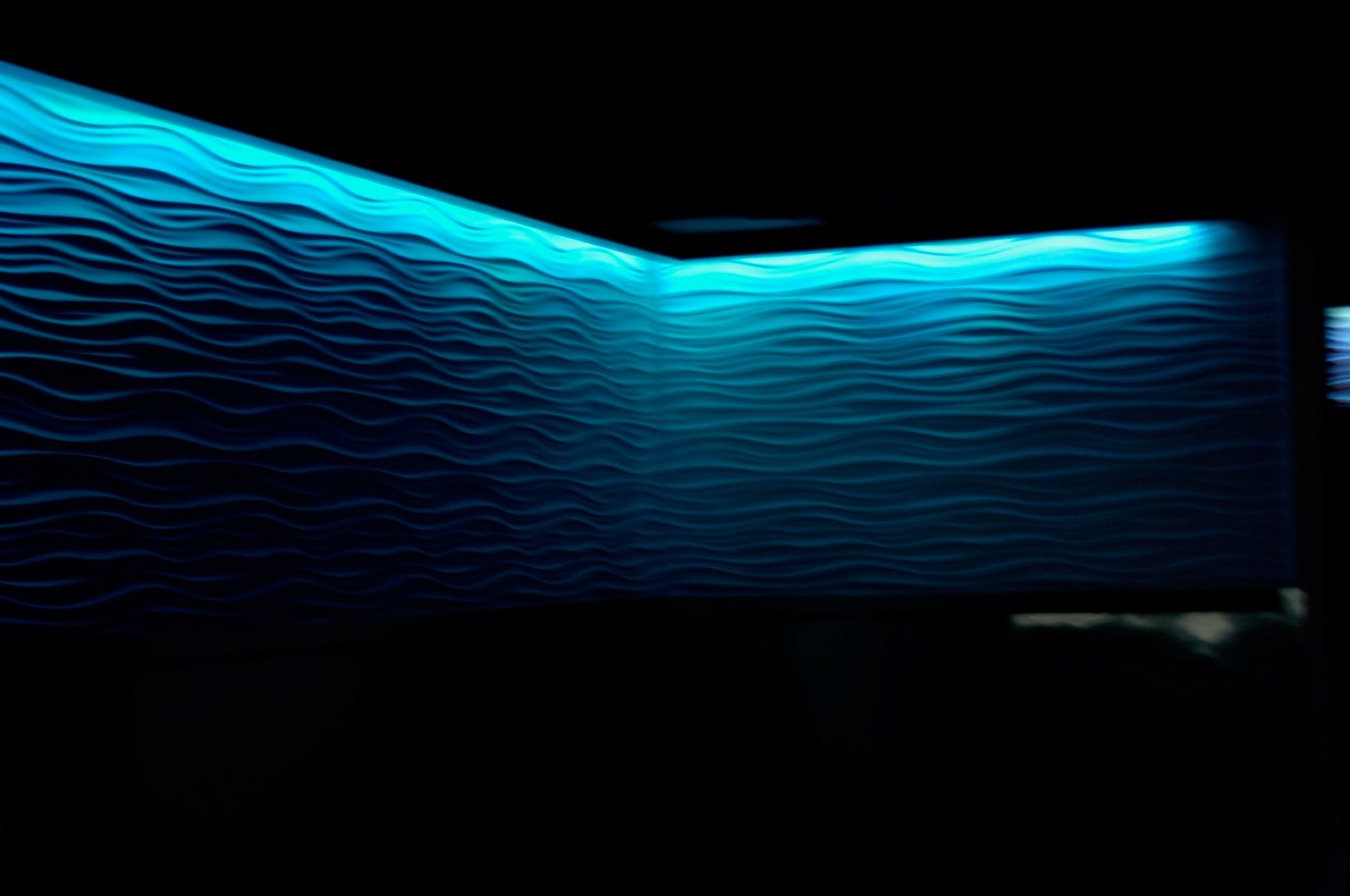 Blue Bar interior with a glowing blue wave wall and layered lighting