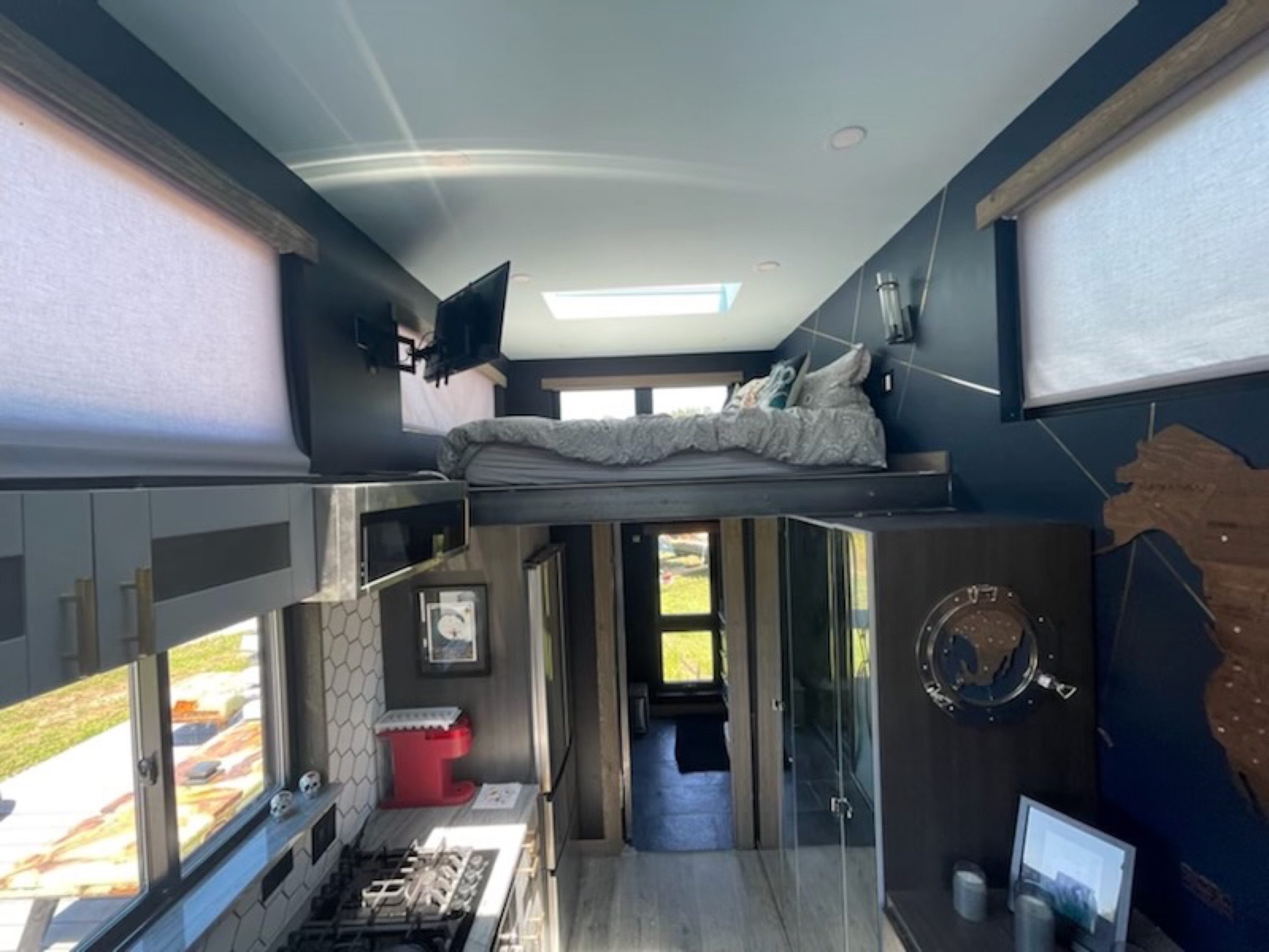 Daylit Mini House interior with lofted sleeping above the compact kitchenette