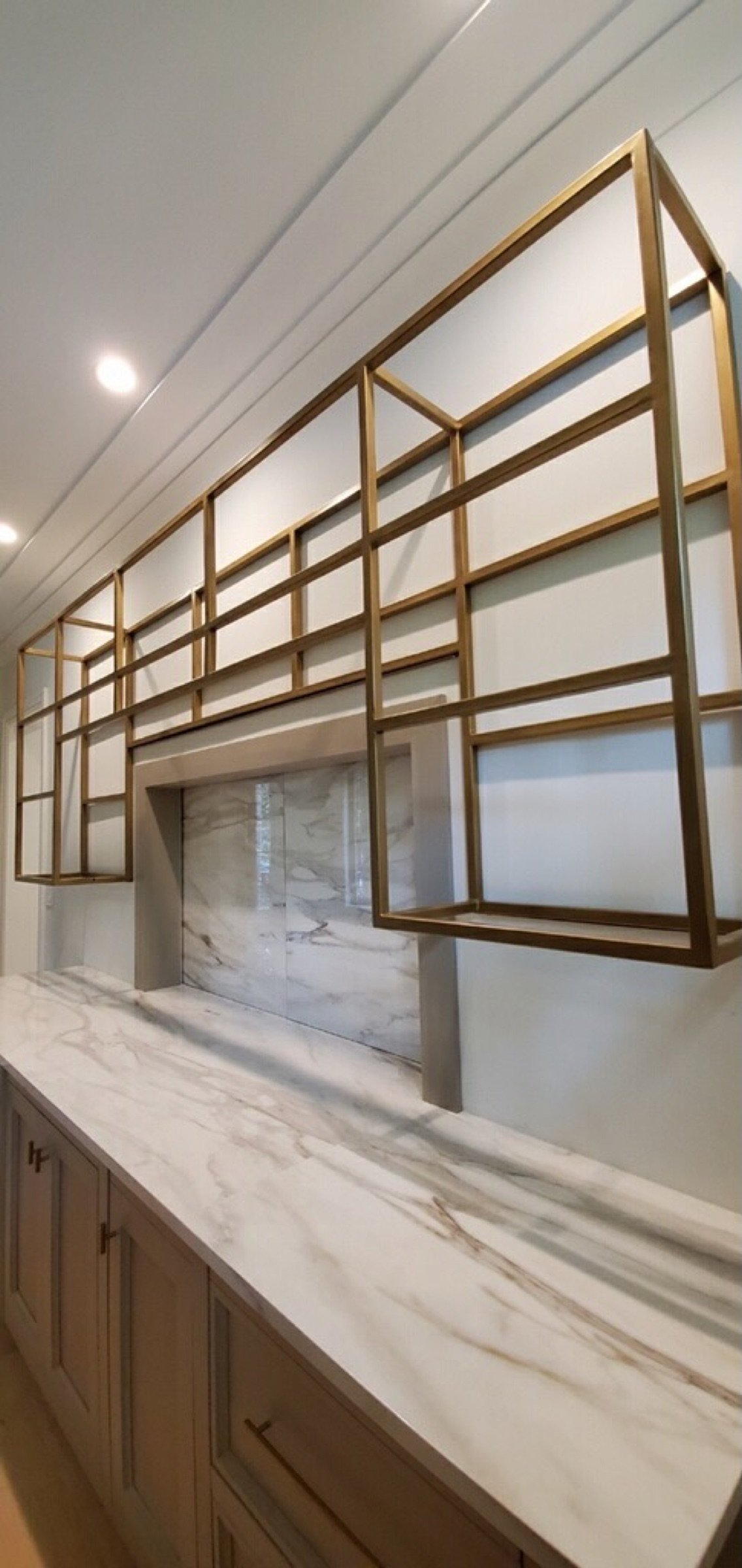 Right-side angle of the gold-finished steel shelving above the bar