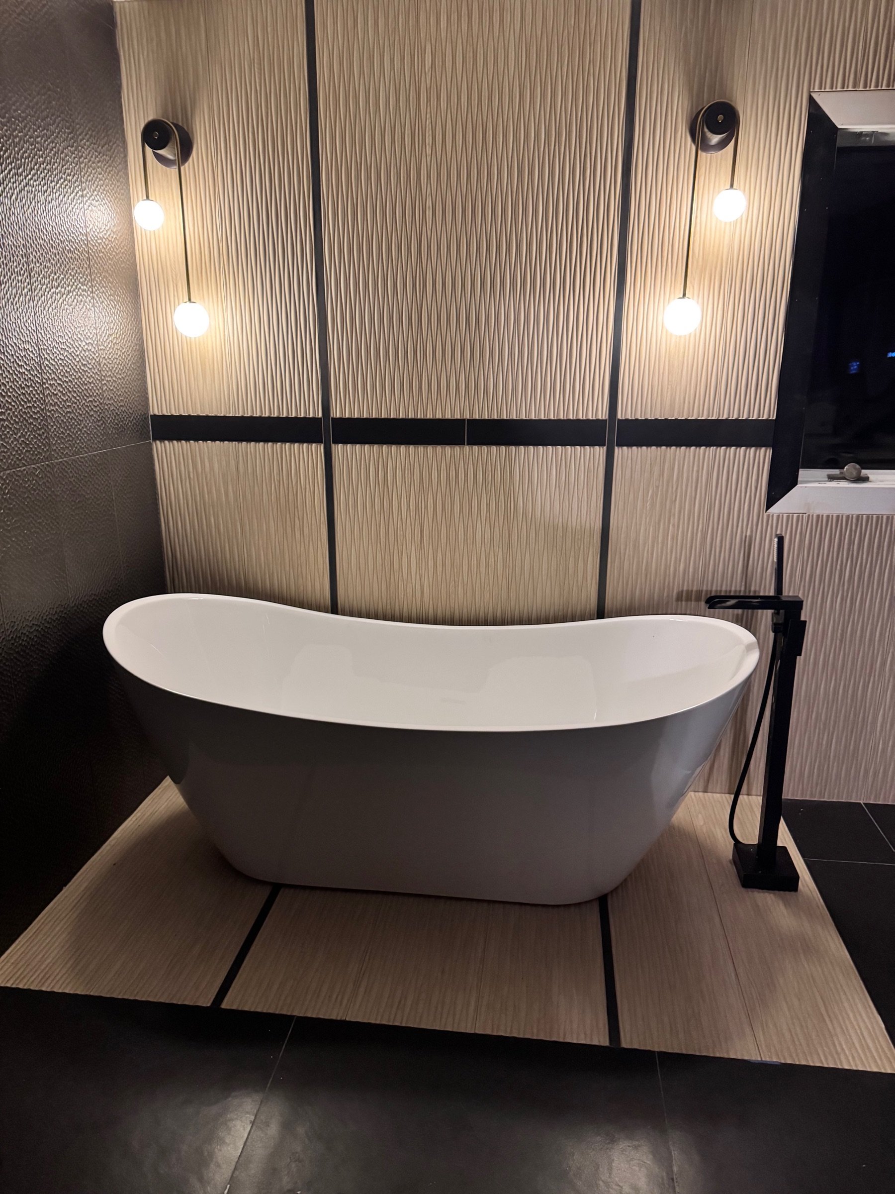 Spa bath with freestanding tub and quiet stone finishes at Robinwood